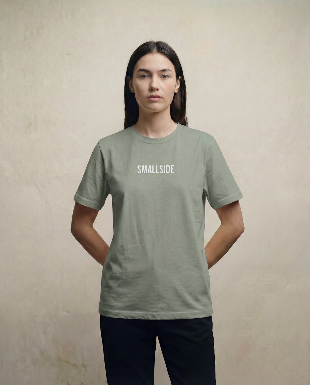 Person wearing a green t-shirt with 'SMALLSIDE' text on a plain background