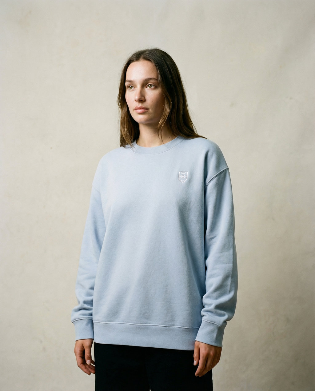 Person wearing a light blue sweatshirt against a plain background